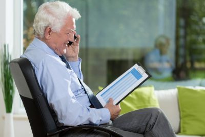 пенсионер разговаривает по телефону