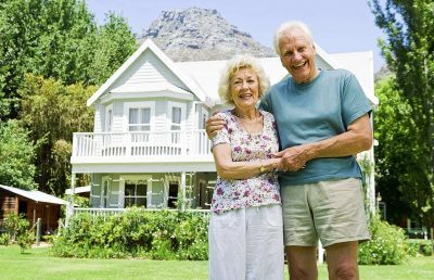 пара пенсионеров на фоне дома