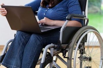 женщина с ноутбуком в инвалидной коляске