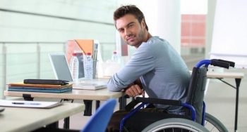 мужчина в инвалидном кресле за столом