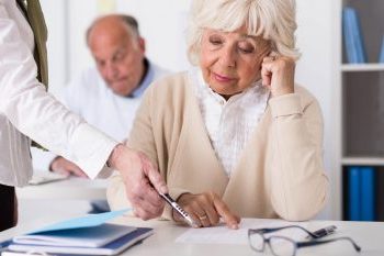 женщина-пенсионер читает документ