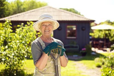 пенсионерка в саду с лопатой