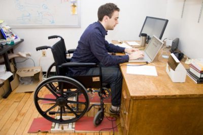 молодой человек за столом в инвалидном кресле